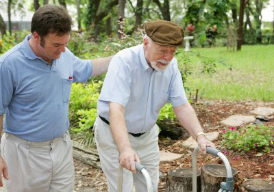 Physical therapist providing gait training and instructing patient on use of a walker